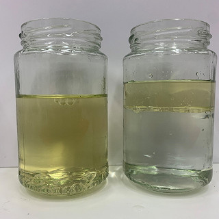 Öl in einem Glas liegt auf Wasser auf